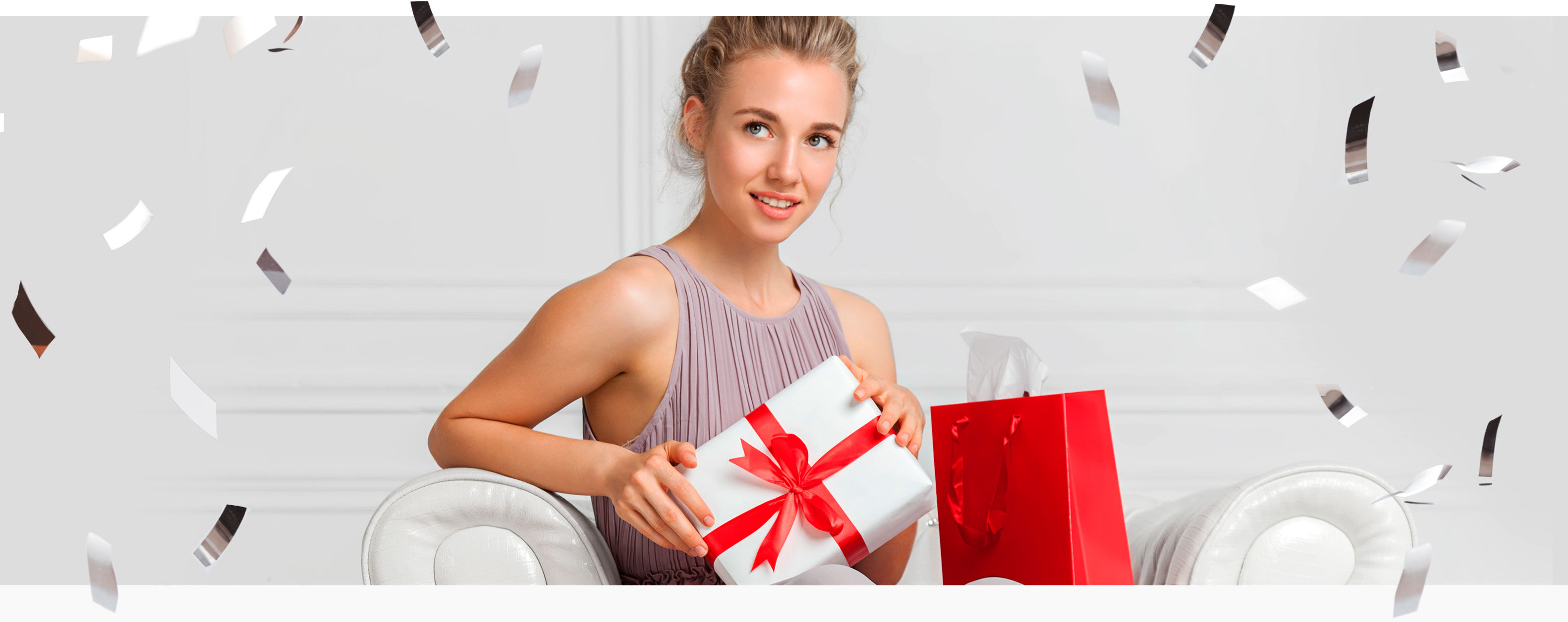 Imagen chica sentada en sofá con regalos de navidad y confeti alrededor 