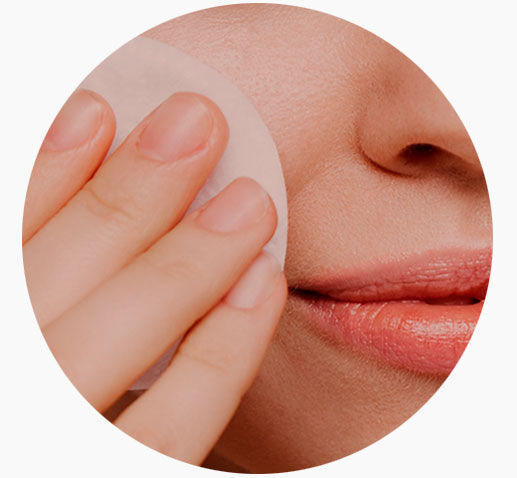 Imagen categoría limpieza facial con una mujer limpiándose la cara con un disco de algodón
