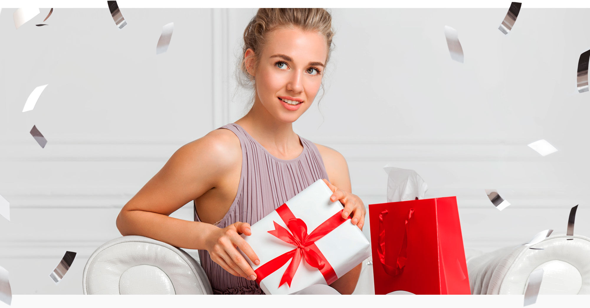 Imagen chica sentada en sofá con regalos de navidad y confeti alrededor 