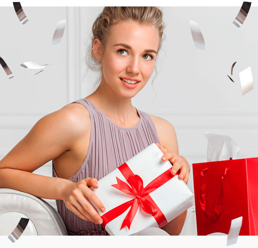 Imagen chica sentada en sofá con regalos de navidad y confeti alrededor 