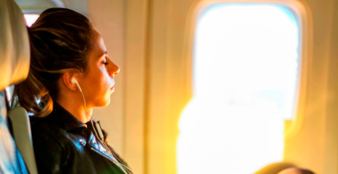 Imagen de una mujer con ojos cerrados en un avión