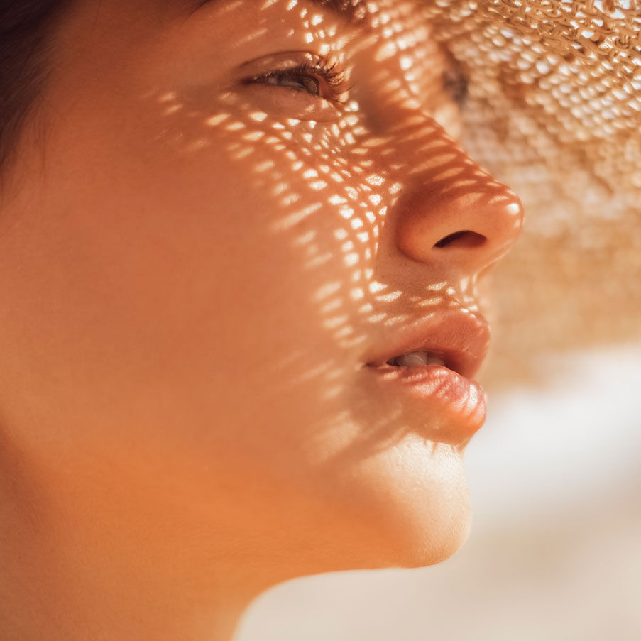 Imagen chica bajo el sol con sombrero  