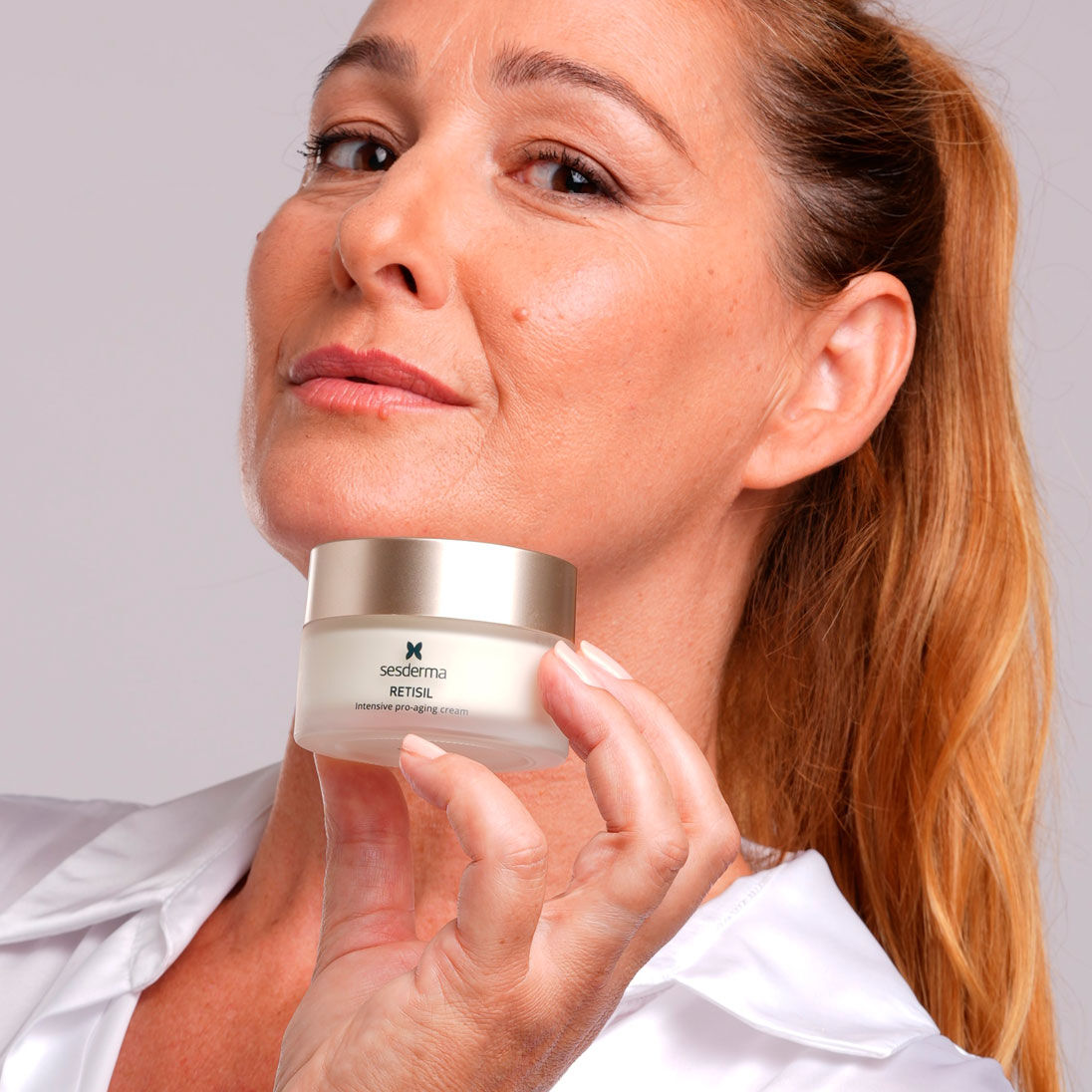 Imagen mujer con el tarro de crema facial c-vit en su mano